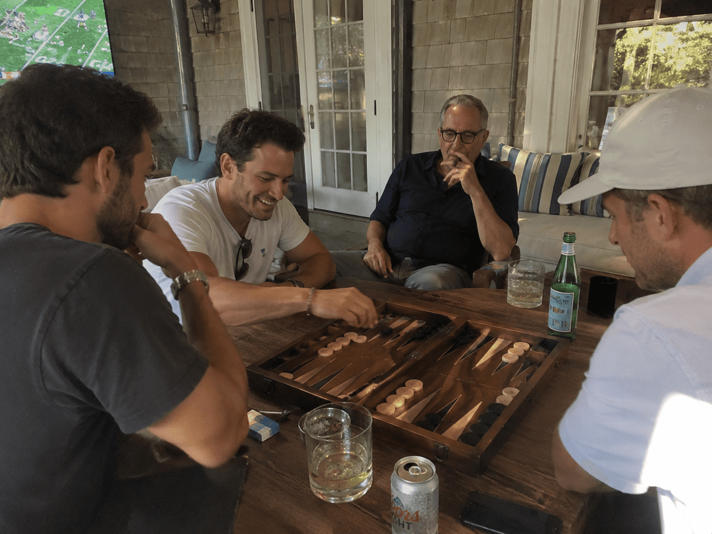 Friends playing backgammon together on a porch